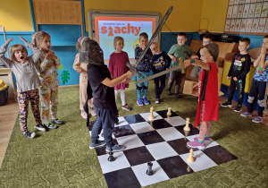 Dzieci pozują do zdjęcia na szachownicy